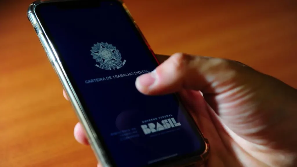 Trabalhador sorrindo ao consultar o PIS/Pasep no celular com tela do app Carteira de Trabalho Digital visível