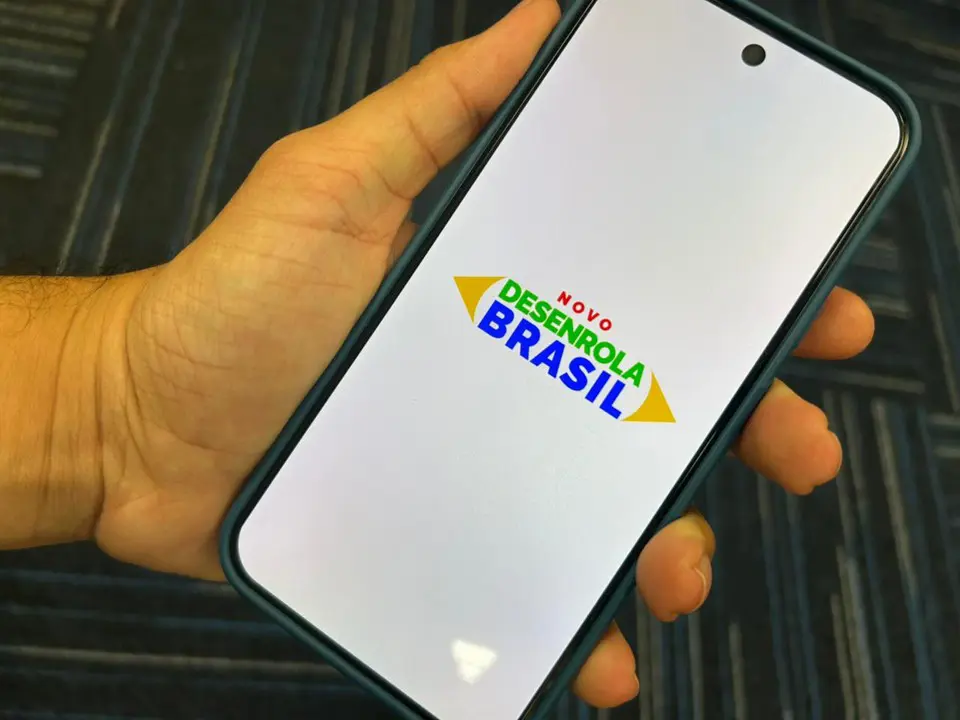 Pessoa acessando Desenrola 2.0 pelo celular com app bancário aberto