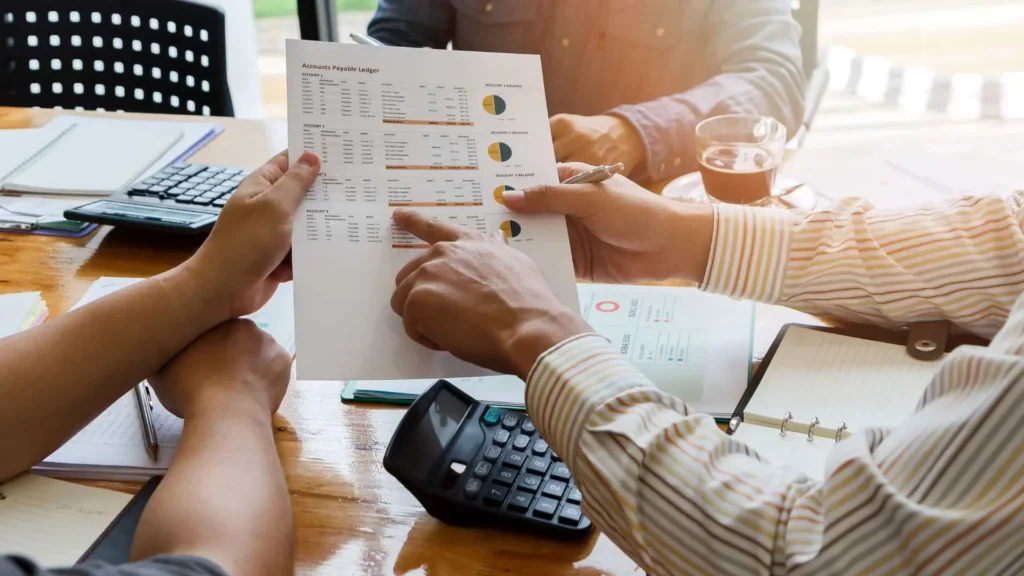 Pessoa calculando economia no Desenrola 2.0 com celular e tabela de descontos