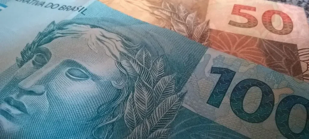 Mulher brasileira consultando extrato de benefício social no celular em casa